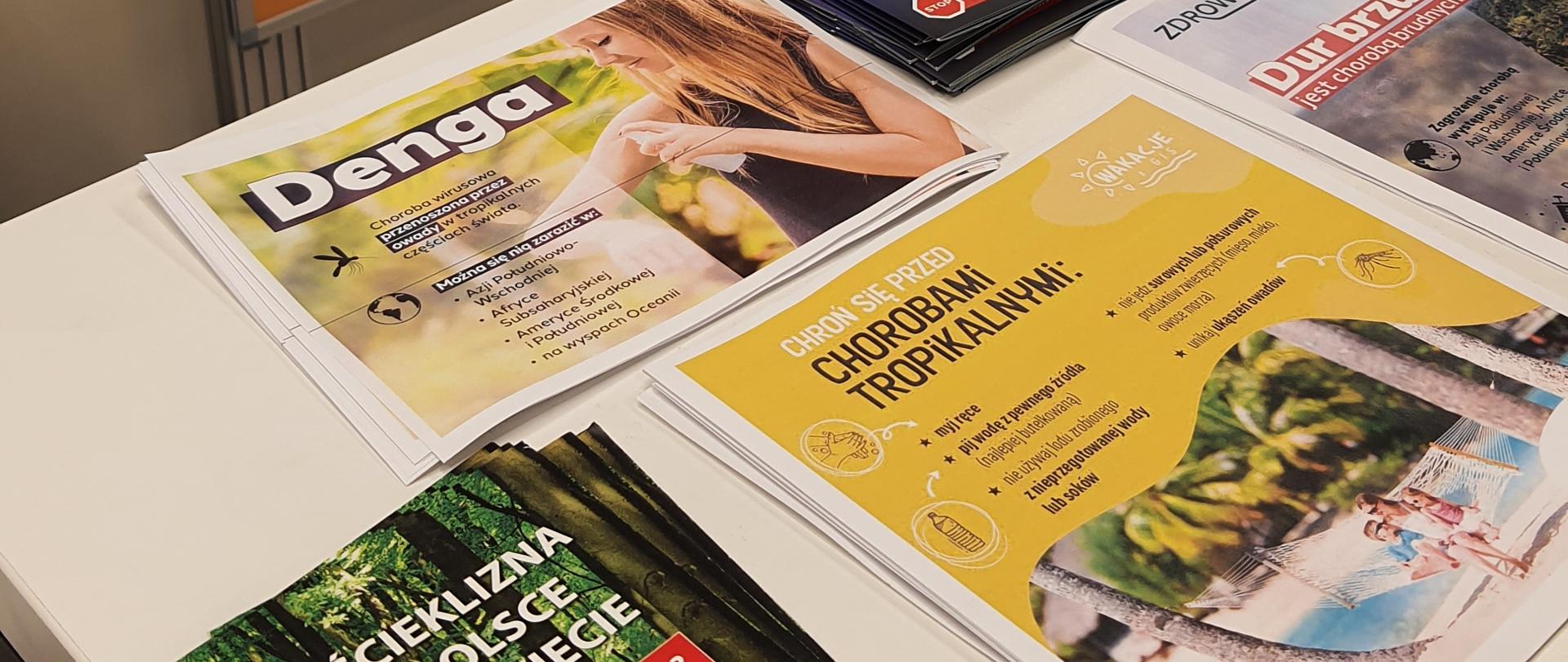 Ogólny widok na stoisko informacyjne z mapą oraz ulotkami rozłożonymi na stole