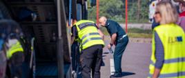 Funkcjonariusz litewskiej służby kontrolnej sprawdza stan techniczny ciężarówki przewożącej samochody. W czynnościach kontrolnych uczestniczy, w roli obserwatora, inspektor ITD.