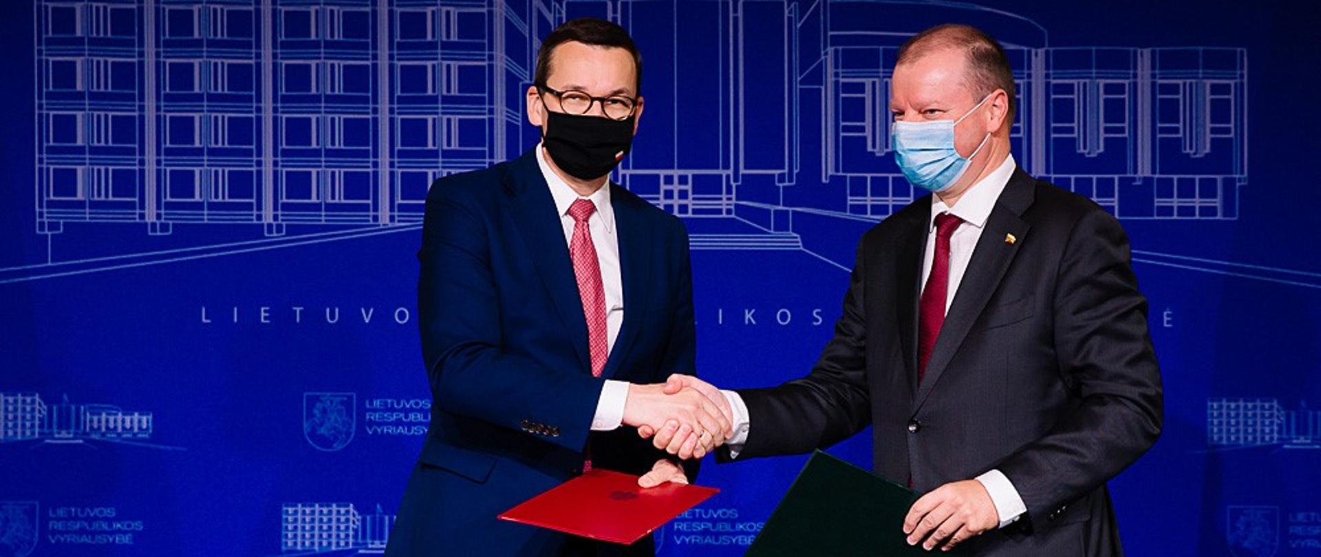 Premierzy Polski i Litwy uściskają sobie dłonie.