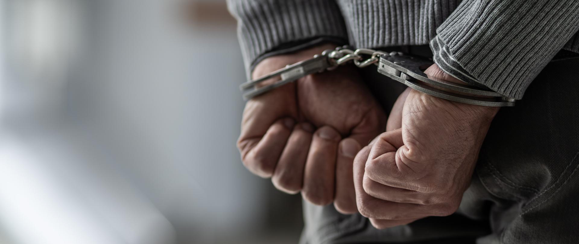 Dłonie w kajdankach.