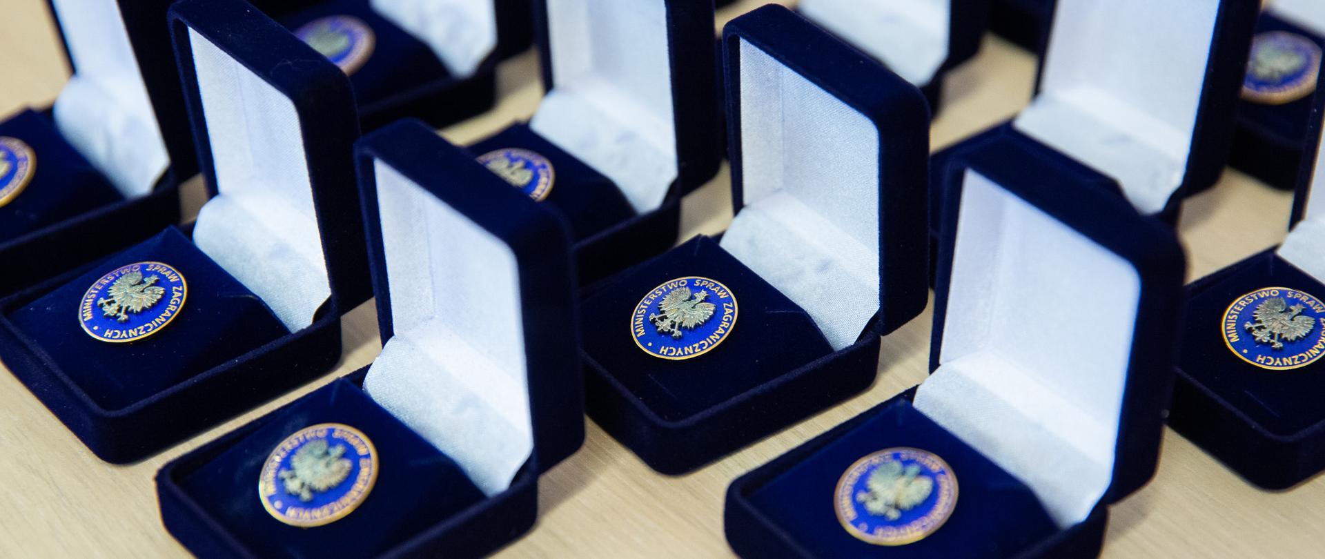 Wpinki Ministerstwa Spraw Zagranicznych w granatowych pudełkach, przygotowane do wręczenia absolwentom aplikacji dyplomatyczno-konsularnej po nadaniu pierwszego stopnia dyplomatycznego.