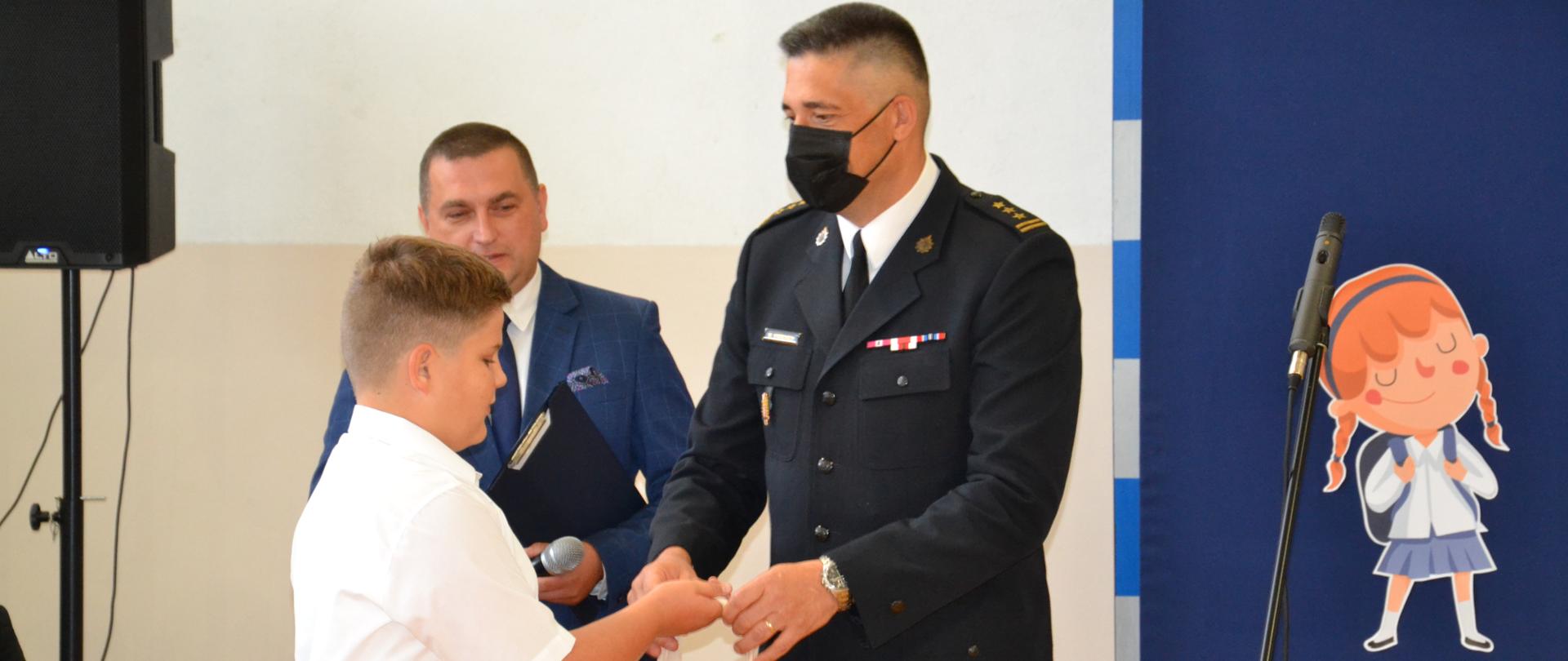 Komendant Powiatowy Wręcza nagrodę i dyplom KG PSP laureatowi konkursu plastycznego