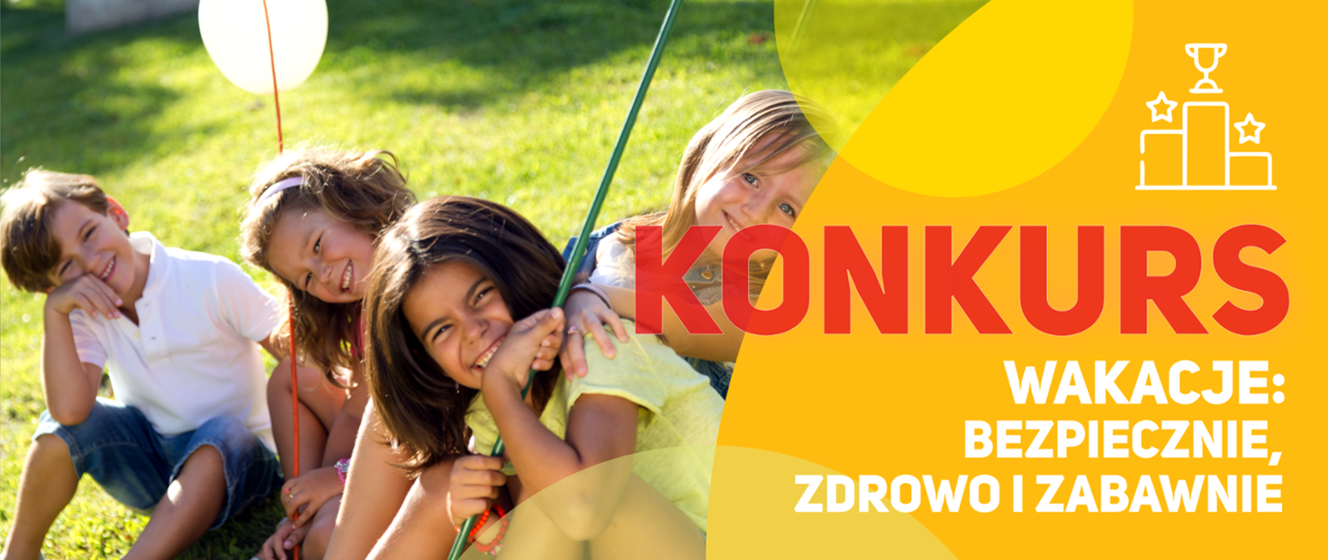 Dzieci siedzące na trawie i śmiejące się.