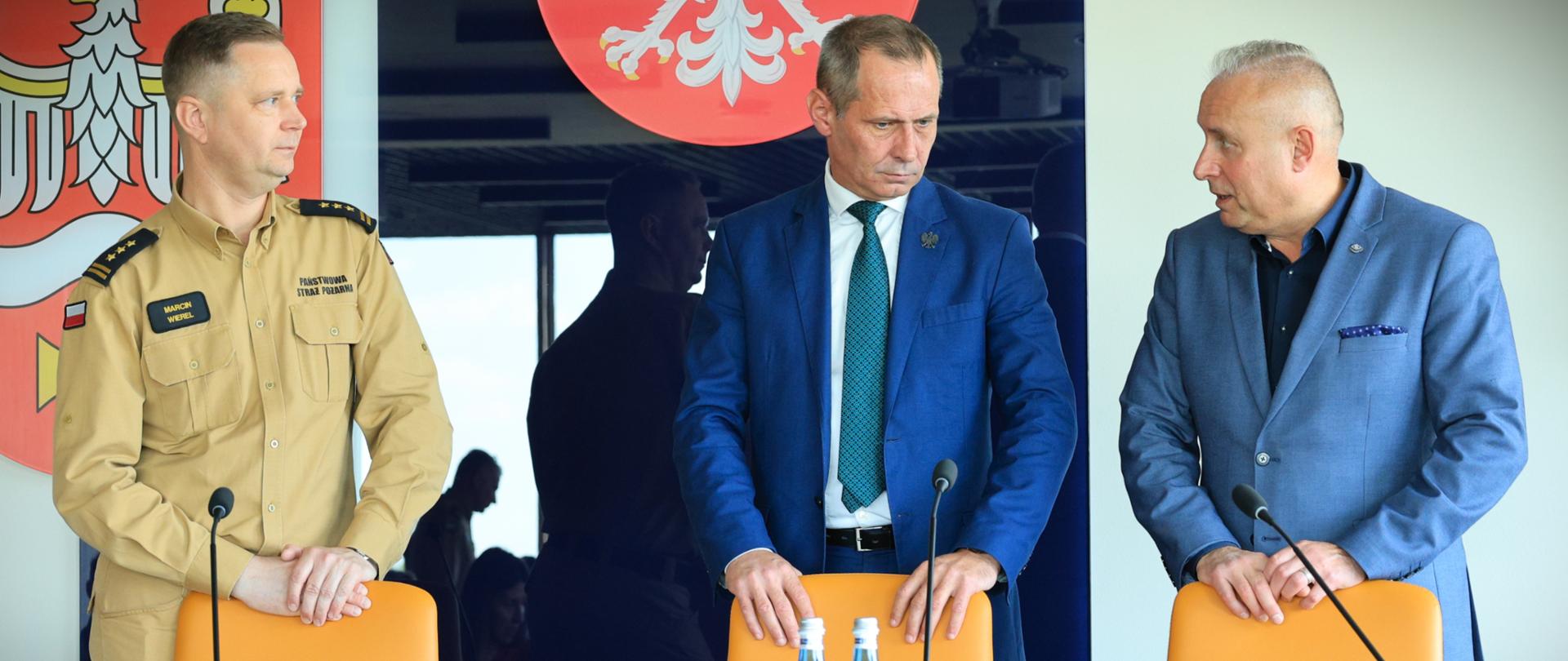 We wtorek 26 maja 2026 r. zastępca podlaskiego komendanta wojewódzkiego Państwowej Straży Pożarnej - st. bryg. Marcin Wierel uczestniczył w spotkaniu zorganizowanym na terenie powiatu wysokomazowieckiego - na zdjęciu przy stole prezydialnym st. bryg. Marcin Wierel, Michał Gąsowski i Bogumił Maksim