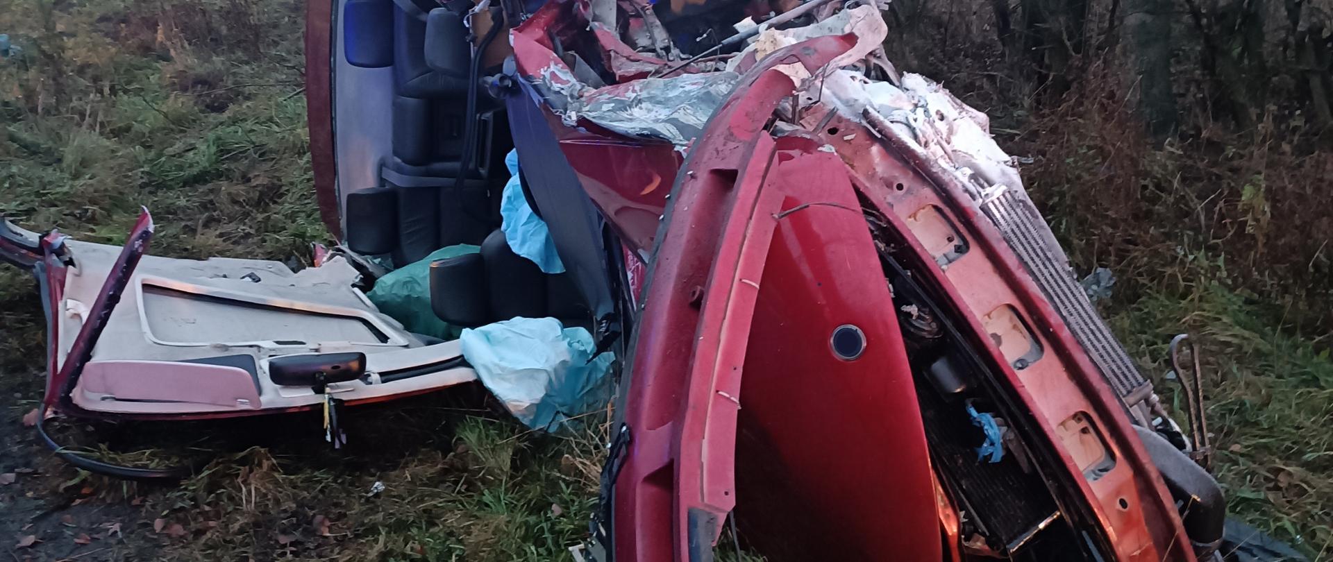 Zdjęcie przedstawia samochód osobowy po wypadku. Samochód leży na prawym boku.