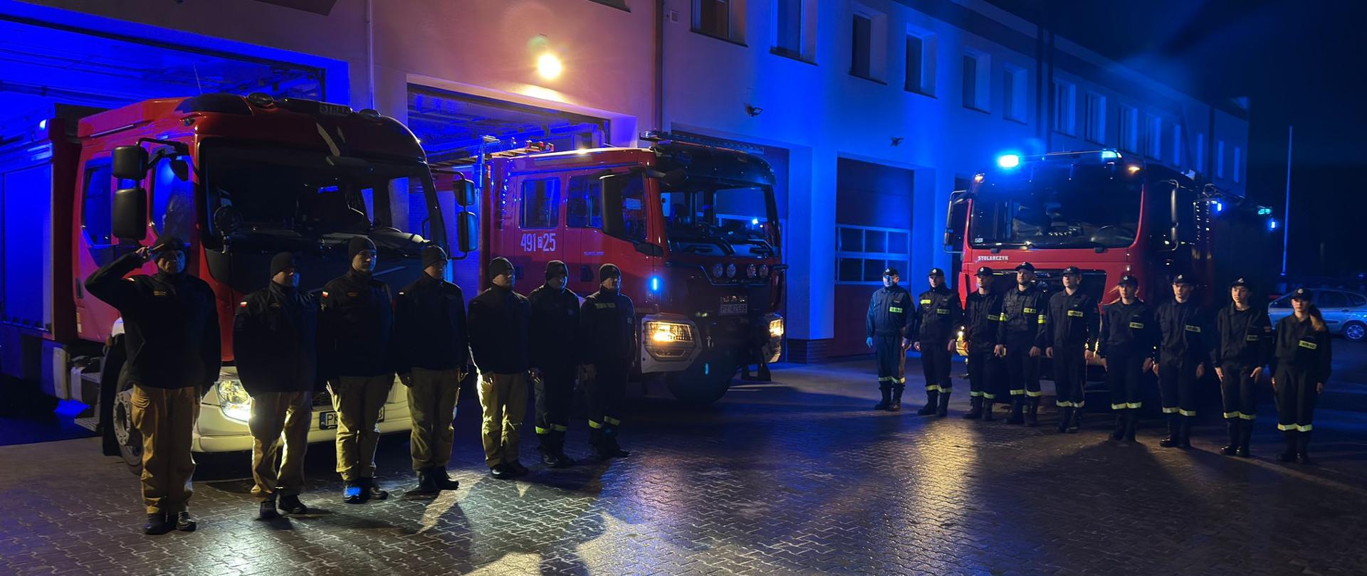 Strażacy ustawieni w szeregu oddają hołd strażakowi OSP, który zmarł