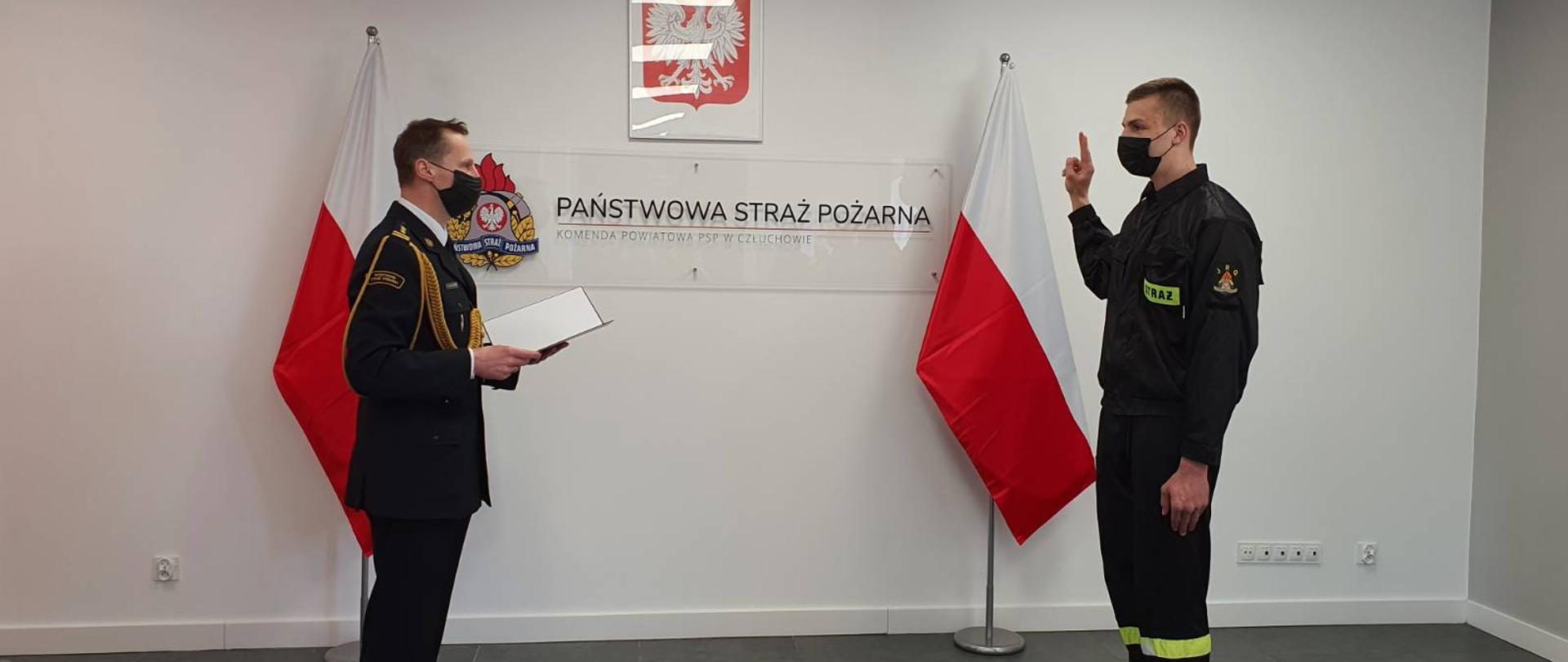 W świetlicy Komendy Powiatowej Państwowej Straży Pożarnej w Człuchowie ślubowanie składa strażak Radosław Dropiewski w obecności Komendanta Powiatowego starszego brygadiera Ernesta Szczepańskiego.