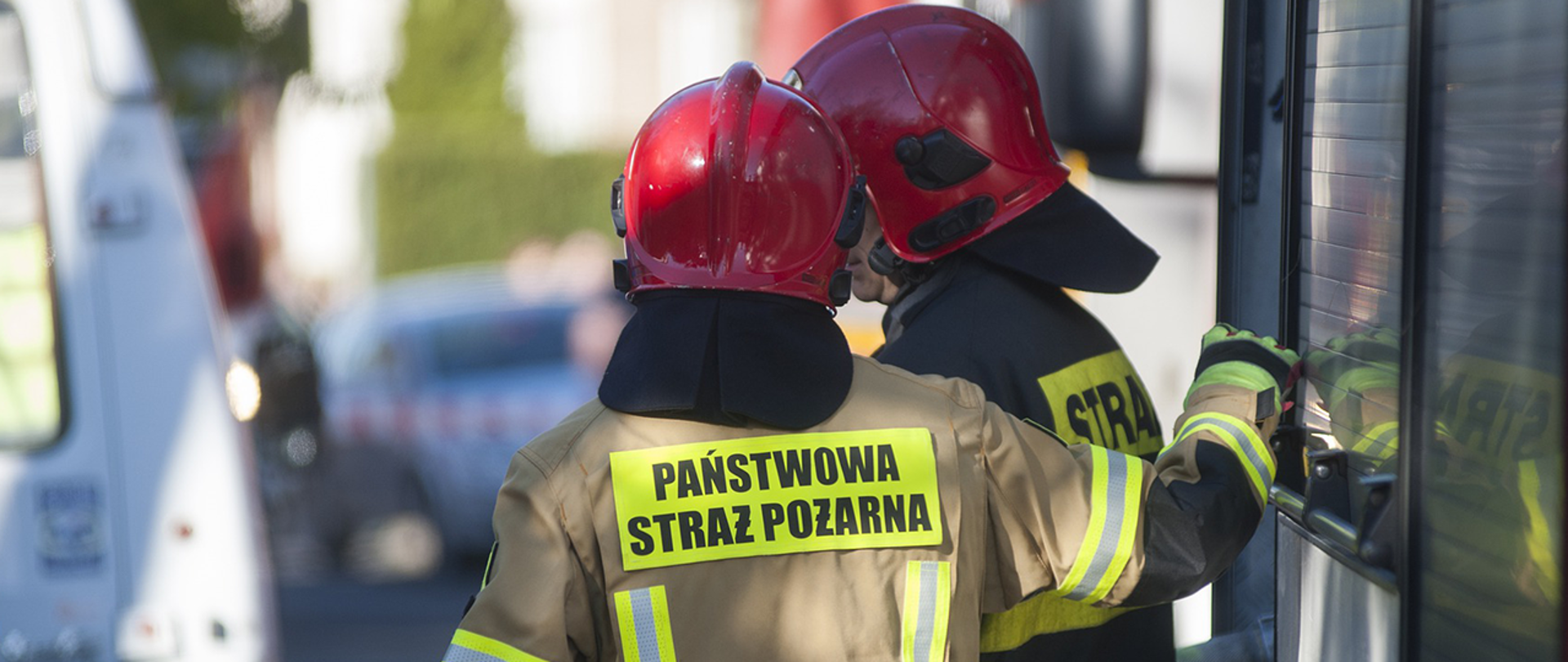 Strażacy podczas interwencji przy wozie strażackim 
