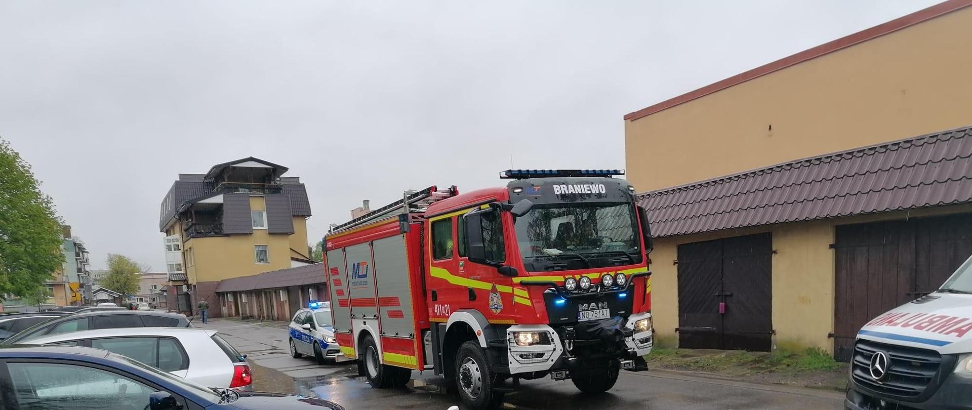 Na zdjęciu duży samochód strażacki, za nim radiowóz policji. Z prawej przód karetki pogotowia.