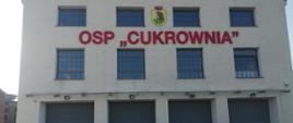 Wizytacja „OSP Cukrownia” na terenie powiatu sokołowskiego- miejsca pobytu uchodźców z Ukrainy. Widać remizę OSP z zewnątrz na bramy garażowe i elewację budynku z napisem „OSP Cukrownia” 