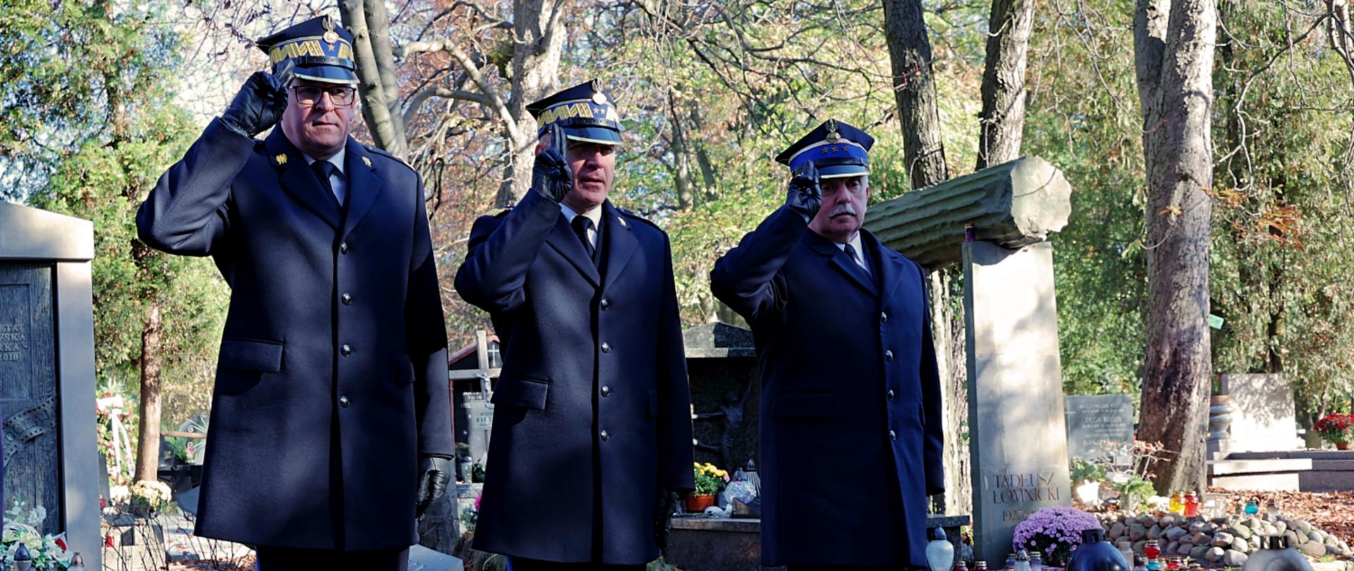 Komendant główny, zastępca komendanta oraz komendant wojewódzki w trakcie oddawania honoru przy grobie zasłużonego strażaka
