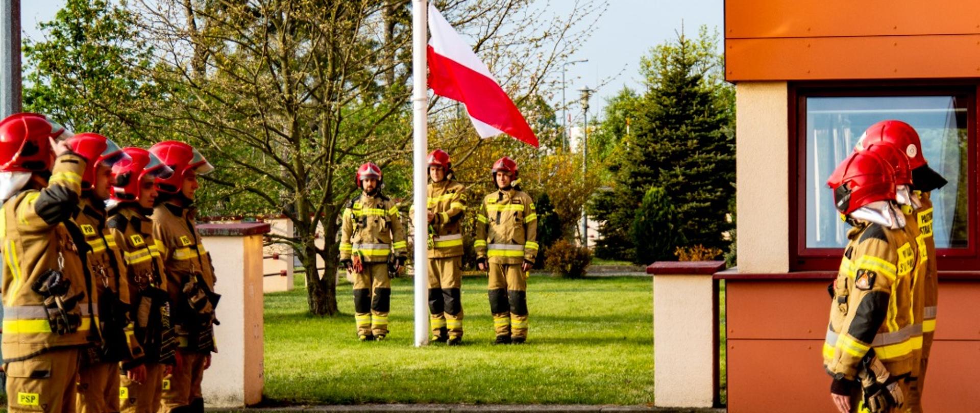 Zdjęcie przedstawia uroczystą zmianę służby w JRG Międzyrzecz w dniu Święta Flagi Rzeczypospolitej Polskiej na placu przed Komendą w Międzyrzeczu