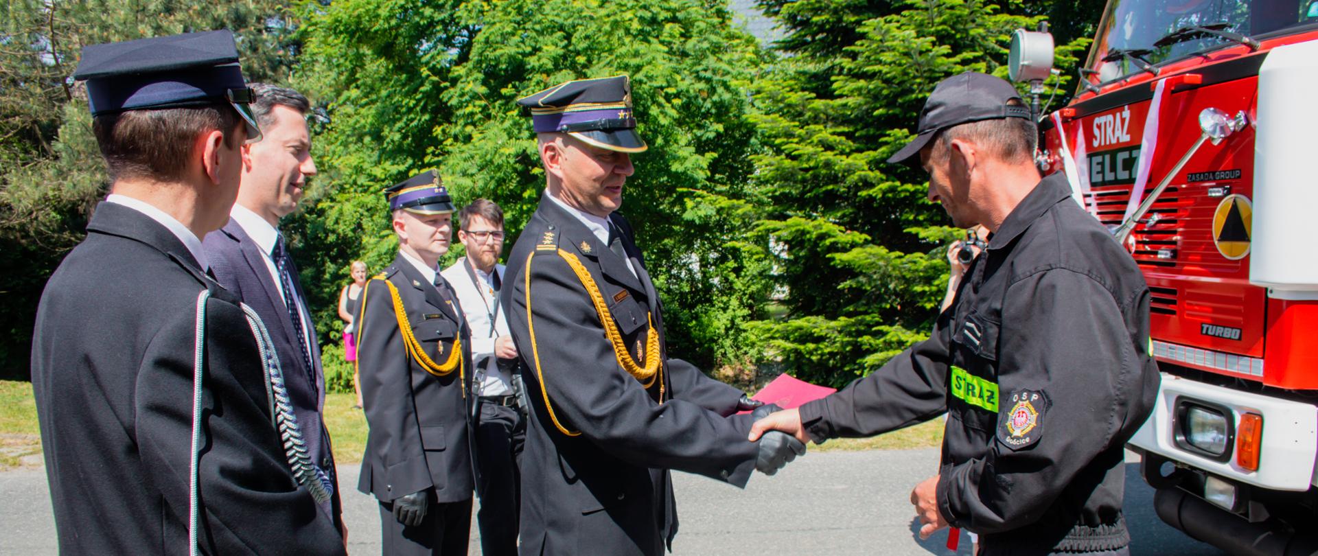 Zdjęcie przedstawia przekazanie samochodu ciężkiego przez Zastępcę Komendanta Wojewódzkiego Arkadiusza Kuśmierskiego 