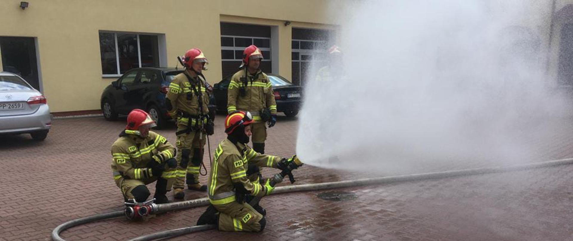 Na zdjęciu widnieją strażacy w trakcie prowadzenia zajęć szkoleniowych z zakresu gaszenia pożarów wewnętrznych. 