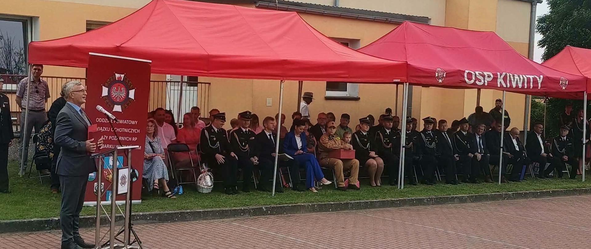Na zdjęciu pod namiotem znajdują się zaproszeni goście na uroczystość 80-lecie Ochotniczej Straży Pożarnej w Kiwitach
