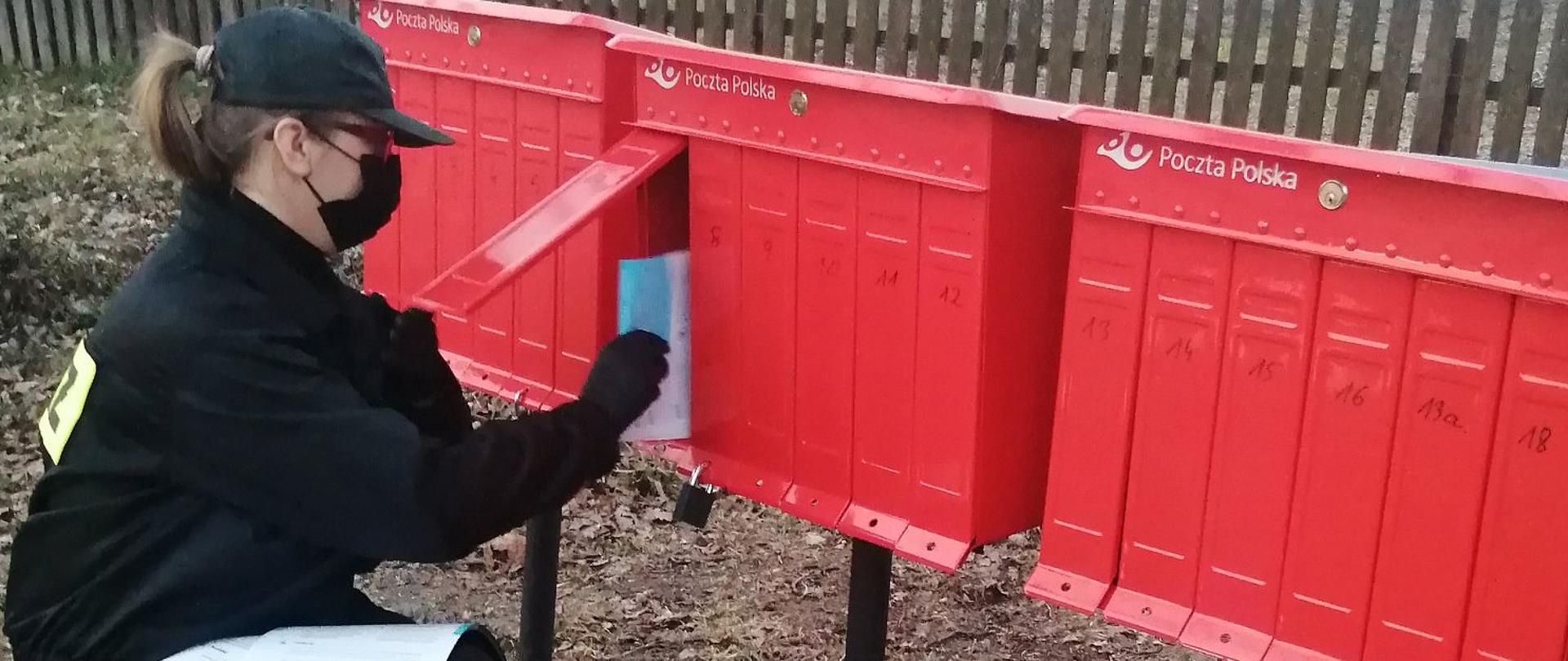 Druhna wkładająca ulotki do skrytek pocztowych