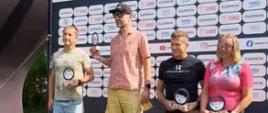 Zdjęcie przedstawia na podium zwycięzców Mistrzostwa Służb Mundurowych i Paramundurowych w ramach Garmin Triathlon Tour Rawa Mazowiecka 2026 w tlr baner z napisem garmin triathlon tour XV edycja