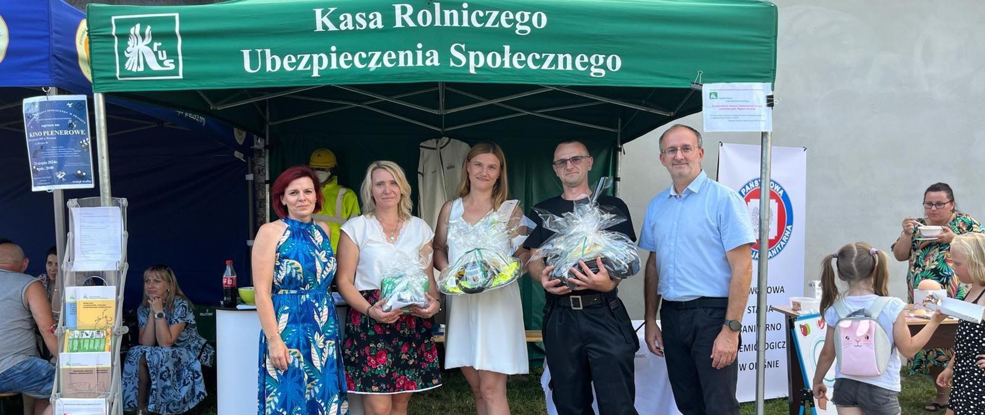 grupa osób na tle stanowiska informacyjnego KRUS