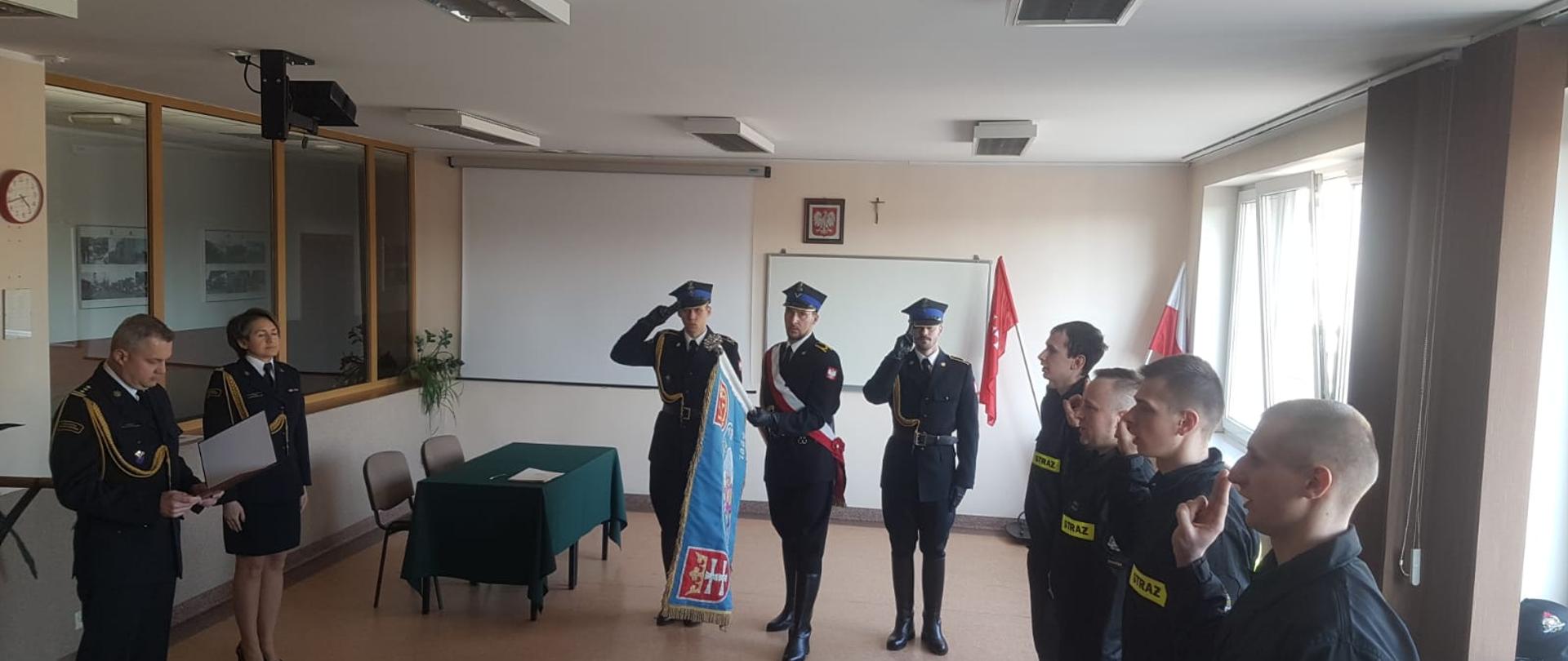 ślubowanie funkcjonariuszy na świetlicy JRG 1 w Gdańsku, w tle poczet sztandarowy