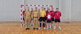 Na zdjęciu widać reprezentację komendy miejskiej państwowej straży pożarnej w Radomiu, któa zajęła drugie miejsce podczas turnieju, zastępcę komendanta miejskiego państwowej straży pożarnej w Radomiu oraz mazowieckiego komendanta wojewódzkiego państwowej straży pożarnej. Zdjęcie zostało zrobione na hali sportowej.