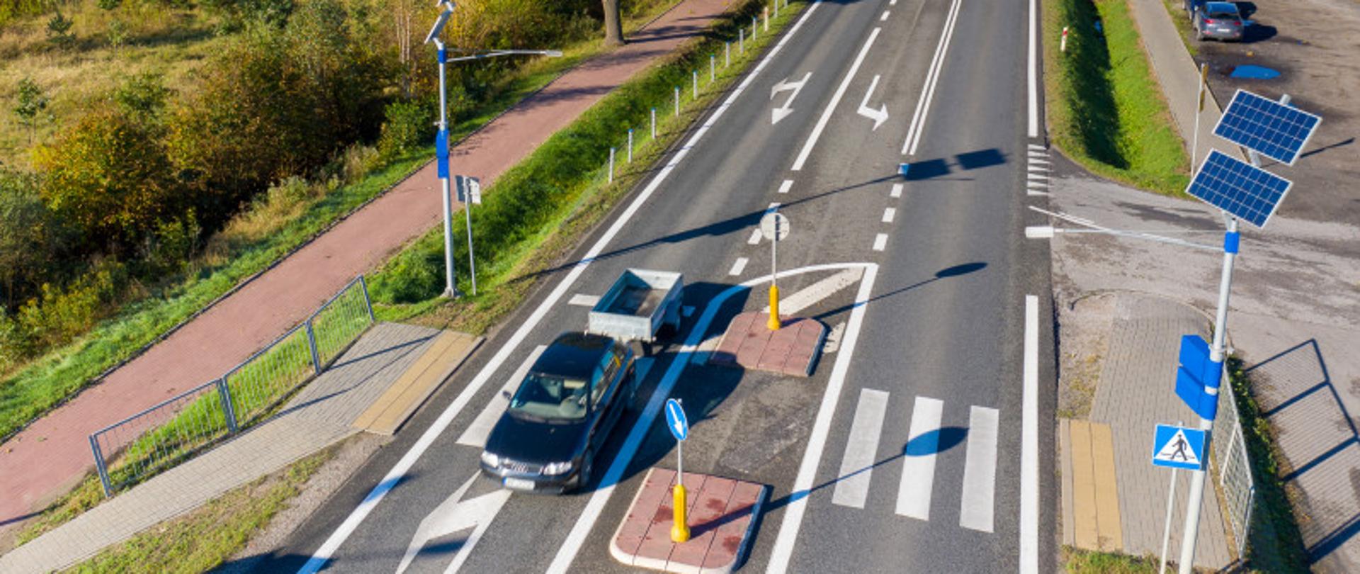 Zdjęcie z lotu ptaka drogi krajowej nr 92 w miejscowości Wielgolas Brzeziński. Widoczne przejście dla pieszych z oświetleniem.