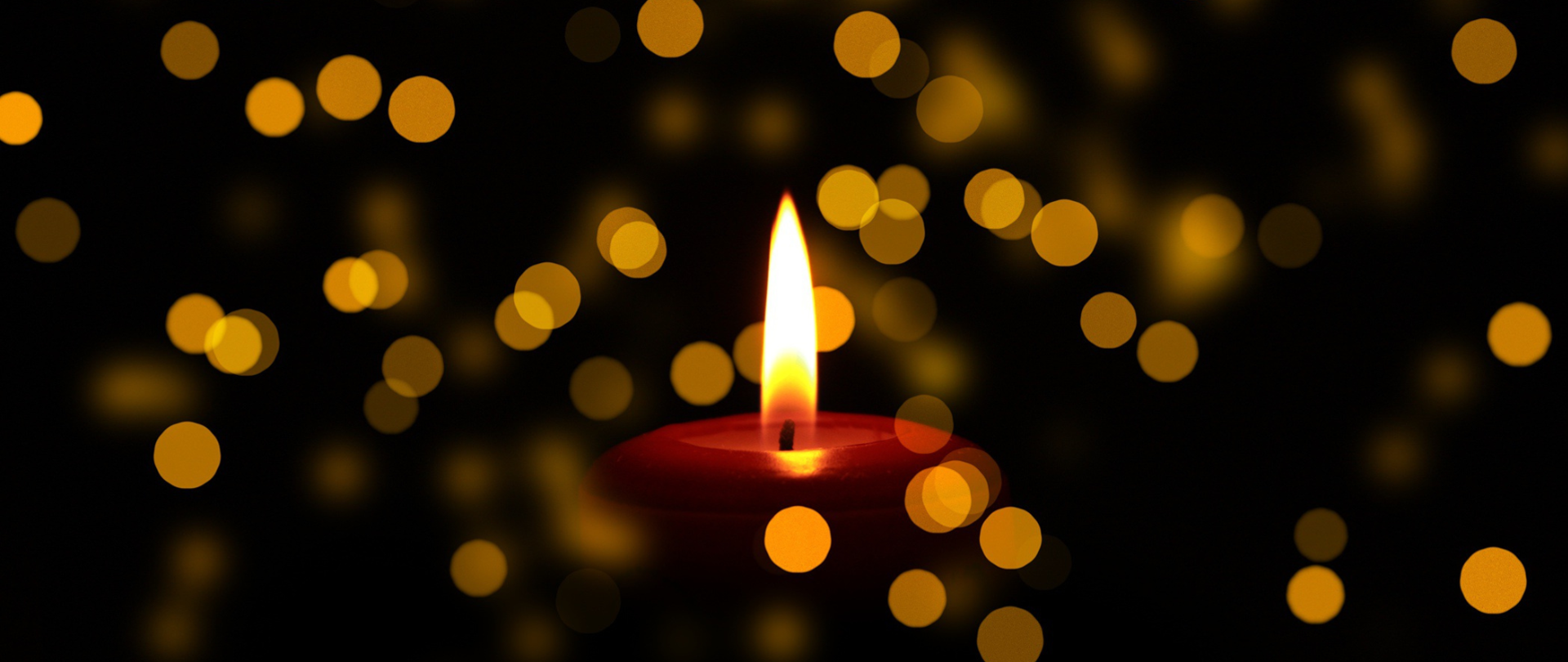 Płonąca świeca na czarnym tle