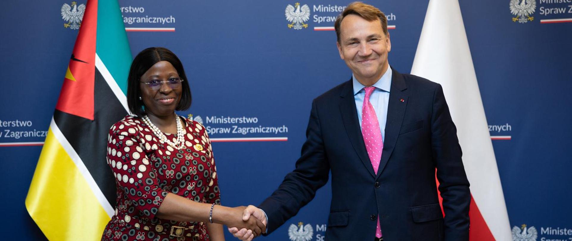 Od lewej strony na tle ścianki Ministerstwa Spraw Zagranicznych RP: minister spraw zagranicznych Mozambiku Maria Manuela dos Santos Lucas ściska dłoń wicepremiera, ministra spraw zagranicznych Polski Radosława Sikorskiego' w tle flagi Namibii i RP;