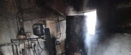 Widać uszkodzone po pożarze pomieszczenie kotłowni oraz wyposażenie pieca