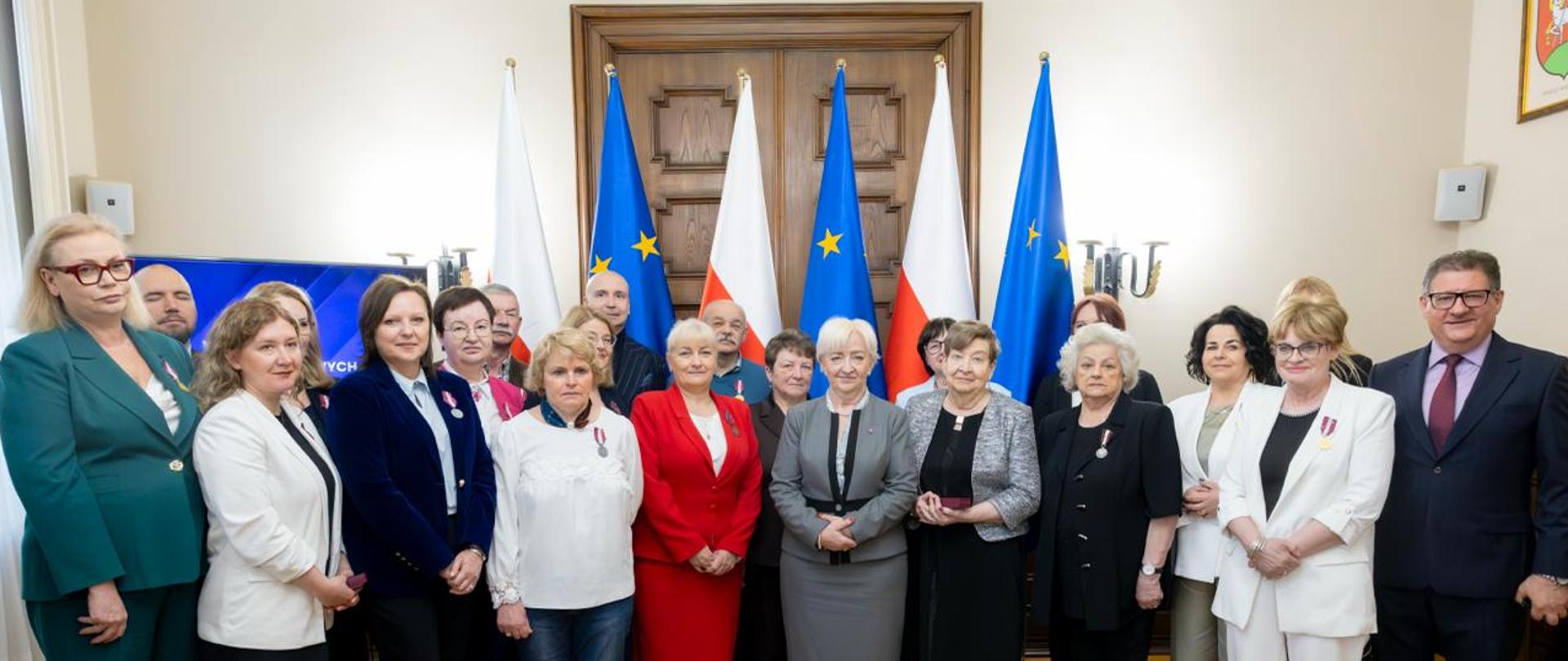 Pracownicy instytucji publicznych i samorządowych województwa łódzkiego, którym zostały nadane odznaczenia państwowe, wraz z wojewodą łódzkim Dorotą Ryl. 
