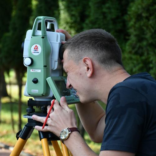 Mężczyzna obsługuje tachimetr ma otwartym powietrzu