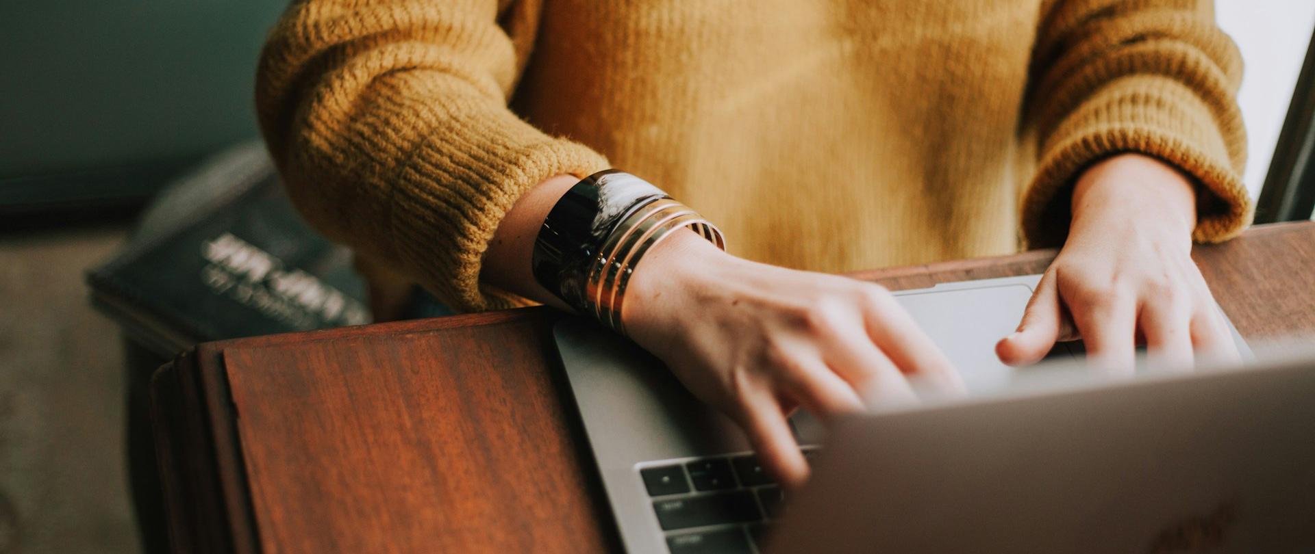 Dłonie na klawiaturze komputera.