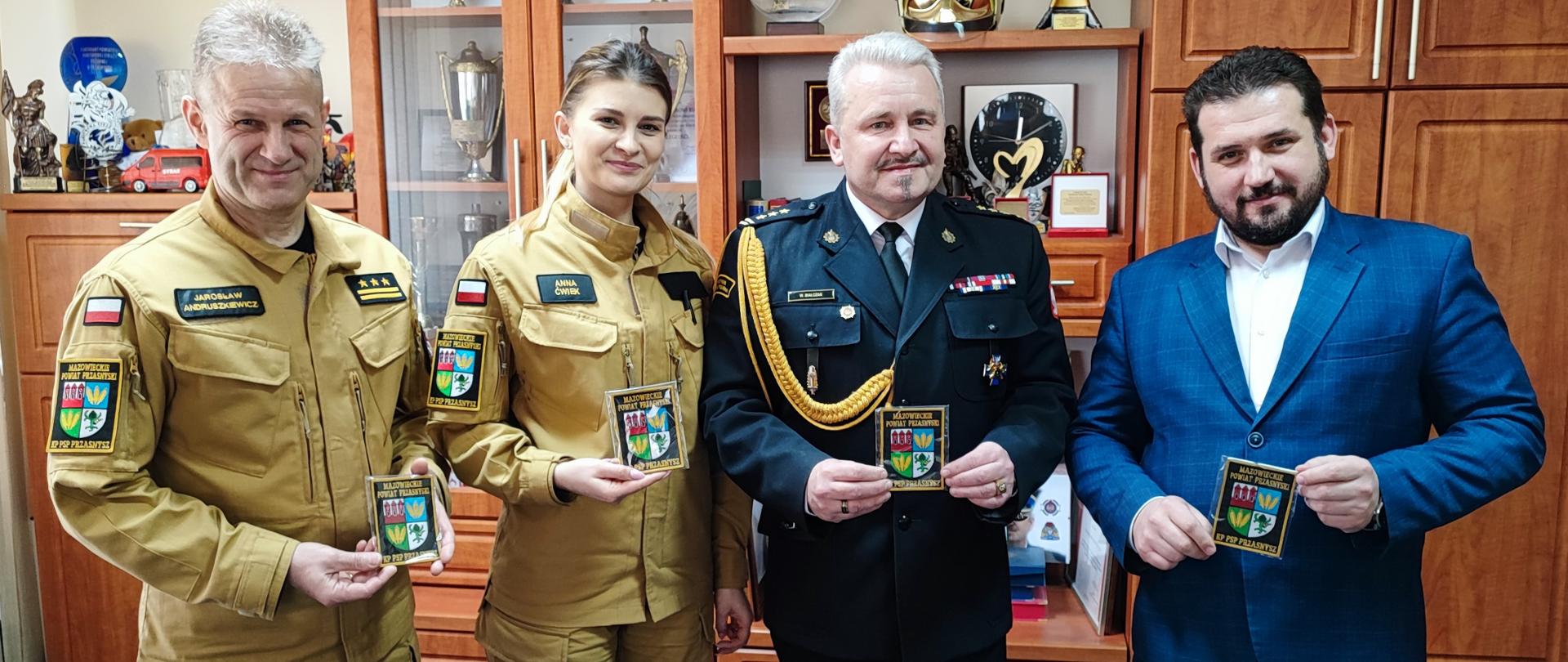 W dniu 26 marca 2024 r. w siedzibie Komendy Powiatowej Państwowej Straży Pożarnej w Przasnyszu, odbyło się spotkanie ze Starostą Powiatu Przasnyskiego Panem Pawłem Mostowym. Na spotkaniu Pan Starosta przekazał na ręce st.bryg. Waldemara Białczaka Komendanta Powiatowego PSP w Przasnyszu naszywki zawierające herb powiatu, nazwę województwa oraz siedzibę Komendy.
Emblematy będą noszone przez strażaków przasnyskiej Komendy na prawym ramieniu bluzy służbowej, kurtki przeciwdeszczowej i bluzy typu polar zgodnie z nowym rozporządzeniem Ministra Spraw Wewnętrznych i Administracji z dnia 29 września 2021 r. w sprawie umundurowania strażaków Państwowej Straży Pożarnej.
Zwarzywszy na fakt, że strażacy z Komendy Powiatowej PSP w Przasnyszu biorą udział w wielu działaniach ratowniczo – gaśniczych, odprawach służbowych i ćwiczeniach na terenie nie tylko powiatu ale województwa mazowieckiego, a nawet całego kraju umieszczenie herbu na umundurowaniu będzie doskonałą promocją dla powiatu przasnyskiego.
W związku z powyższym na wniosek Komendanta Powiatowego PSP w Przasnyszu Zarząd Powiatu Przasnyskiego podjął decyzję o sfinansowania tego promocyjnego dla Powiatu przedsięwzięcia i zakupił 180 szt. naszywek za kwotę 3321,00 złotych.
Bardzo dziękujemy za wsparcie, będziemy nosić z dumą herb naszego Powiatu podczas wykonywania obowiązków służbowych.
Opracował: Oficer Prasowy Komendanta Powiatowego PSP w Przasnyszu: kpt. Piotr Kuligowski.
Zdjęcia: KP PSP w Przasnyszu.
