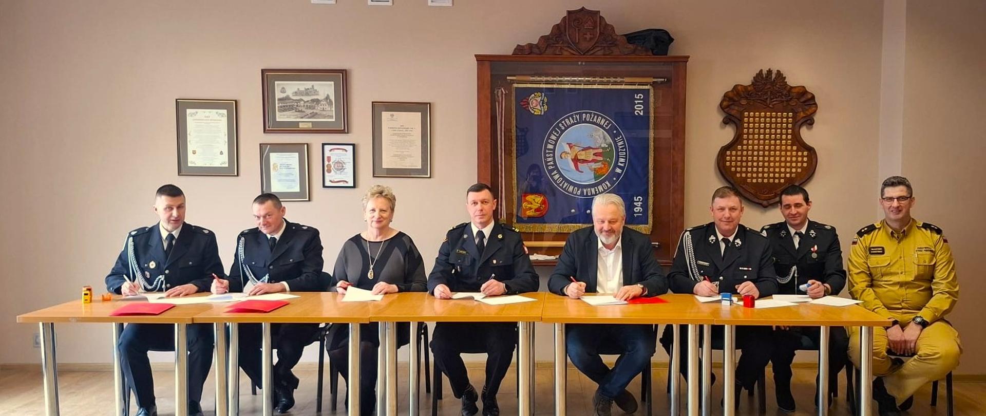 Strony umowy przy stole podpisują umowy