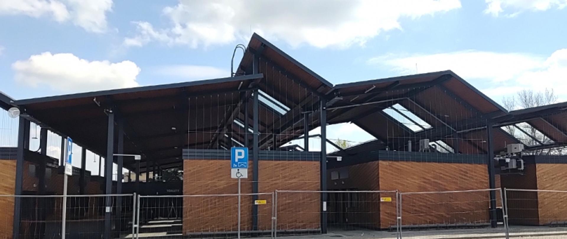 Wiaty targowe, pod którymi znajdują się drewniane sklepy.