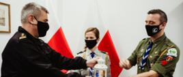Zdjęcie przedstawia pomorskiego komendanta wojewódzkiego PSP przyjmującego Światełko Pokoju od harcerzy ZHP.