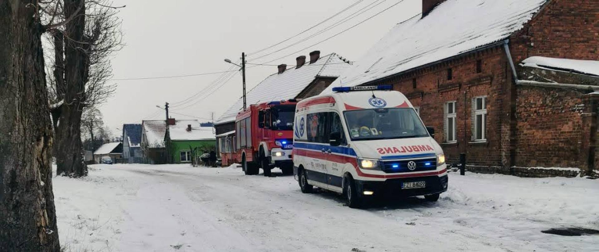 Czad wciąż atakuje! - Ambulans pogotowia i wóz strażacki stoją przed domem osób poszkodowanych