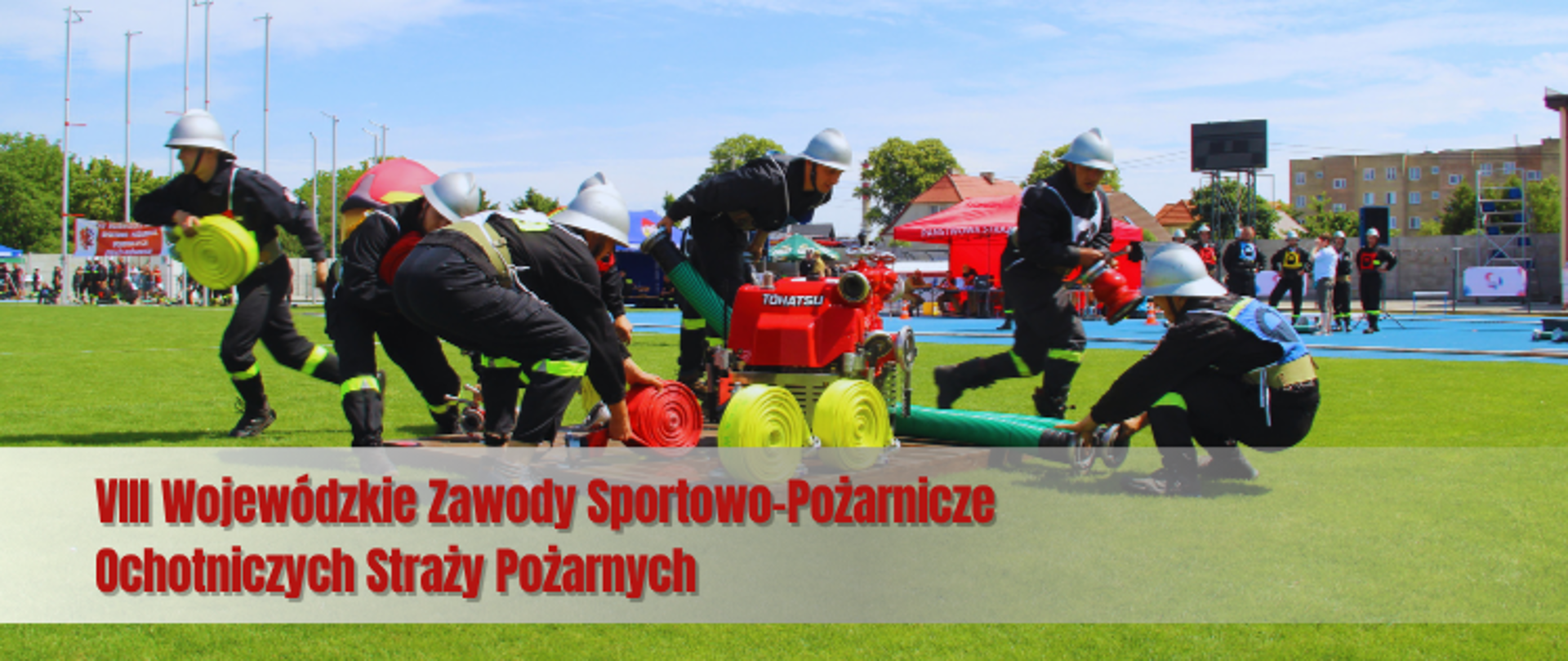 Baner ze zdjęciem, gdzie 6 zawodników w hełmach srebrnych na głowie chwytają w biegu sprzęt pożarniczy. W ich środku motopompa. W dali widok na stadion i innych zawodników. 