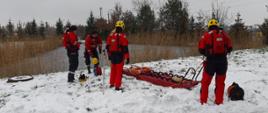 Strażacy ubrani w ubrania do pracy w wodzie przygotowują sprzęt do wejścia do wody