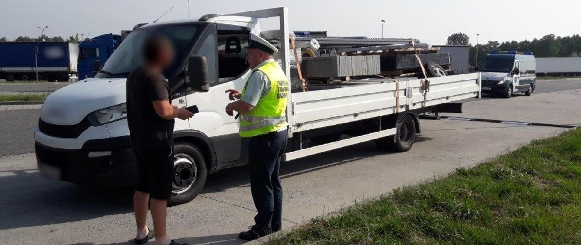Na pierwszym planie (od lewej strony) stoi kierowca samochodu dostawczego i umundurowany inspektor łódzkiej ITD. Przed nimi kontrolowany pojazd po przeprowadzonym ważeniu na przenośnych wagach ITD. W tle stoi oznakowany radiowóz ITD typu furgon.