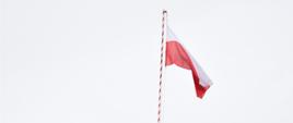 Na zdjęciu widać wciągnietą na masz flagę Polski.