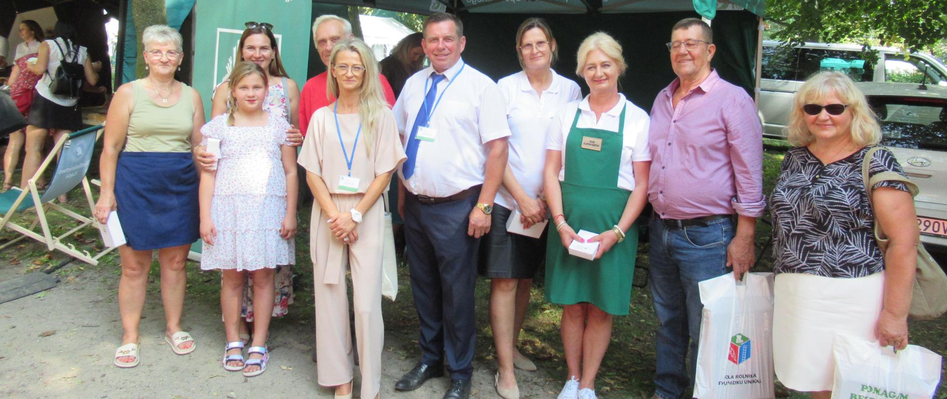 Przed stoiskiem informacyjnym KRUS stoi grupa 10 osób.