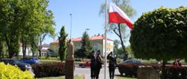 Podniesienie flagi państwowej na maszt przez poczet flagowy w sile 3 strażaków 