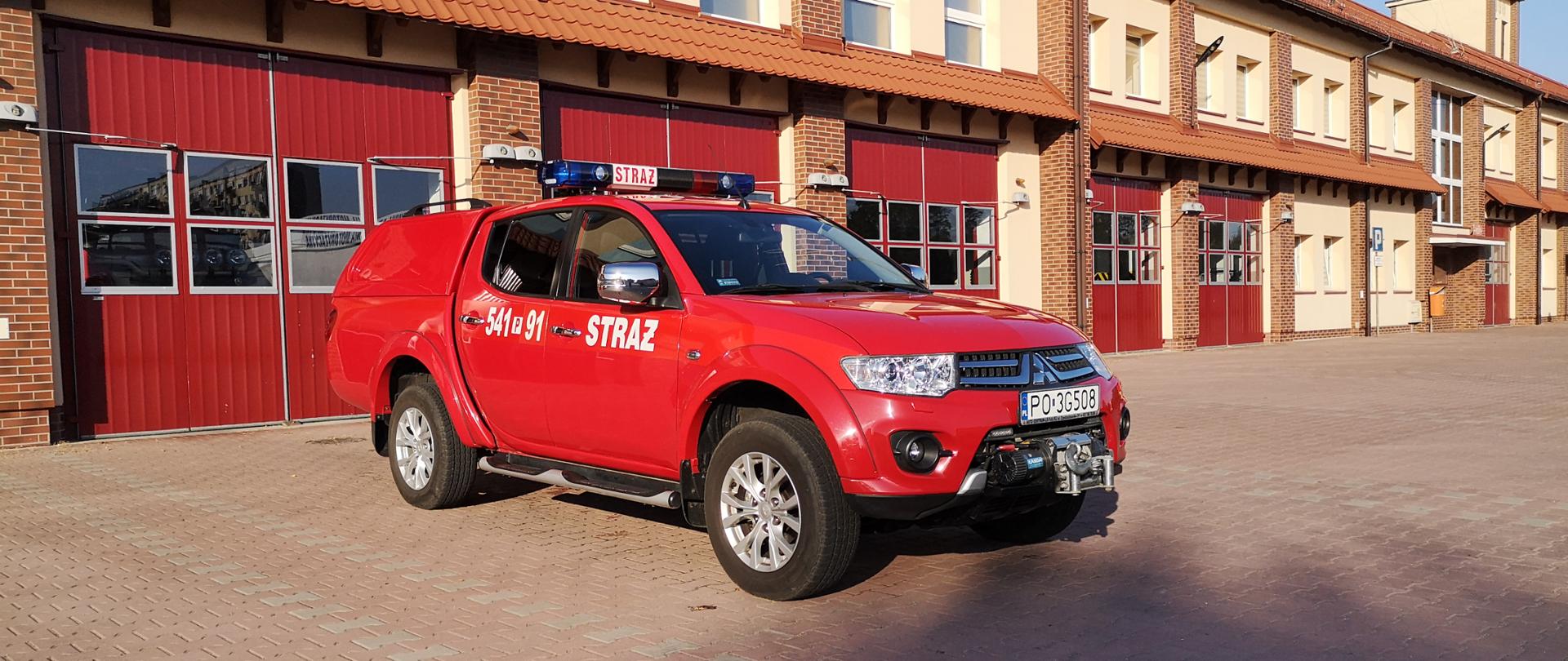 Na zdjęciu lekki samochód specjalny rozpoznawczo-ratowniczy na placu manewrowym przed garażami Jednostki Ratowniczo-Gaśniczej