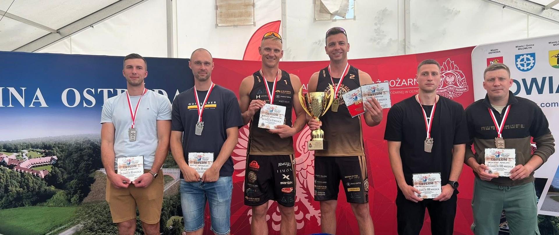 Mistrzostwa Polski Strażaków Państwowej Straży Pożarnej w Siatkówce Plażowej. Zdjęcie przedstawia strażaków PSP podczas wręczenie nagród. 