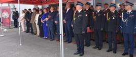 Zdjęcie przedstawia zaproszonych gości ustawionych pod pawilonem na placu wewnętrznym komendy w trakcie uroczystej zbiórki.