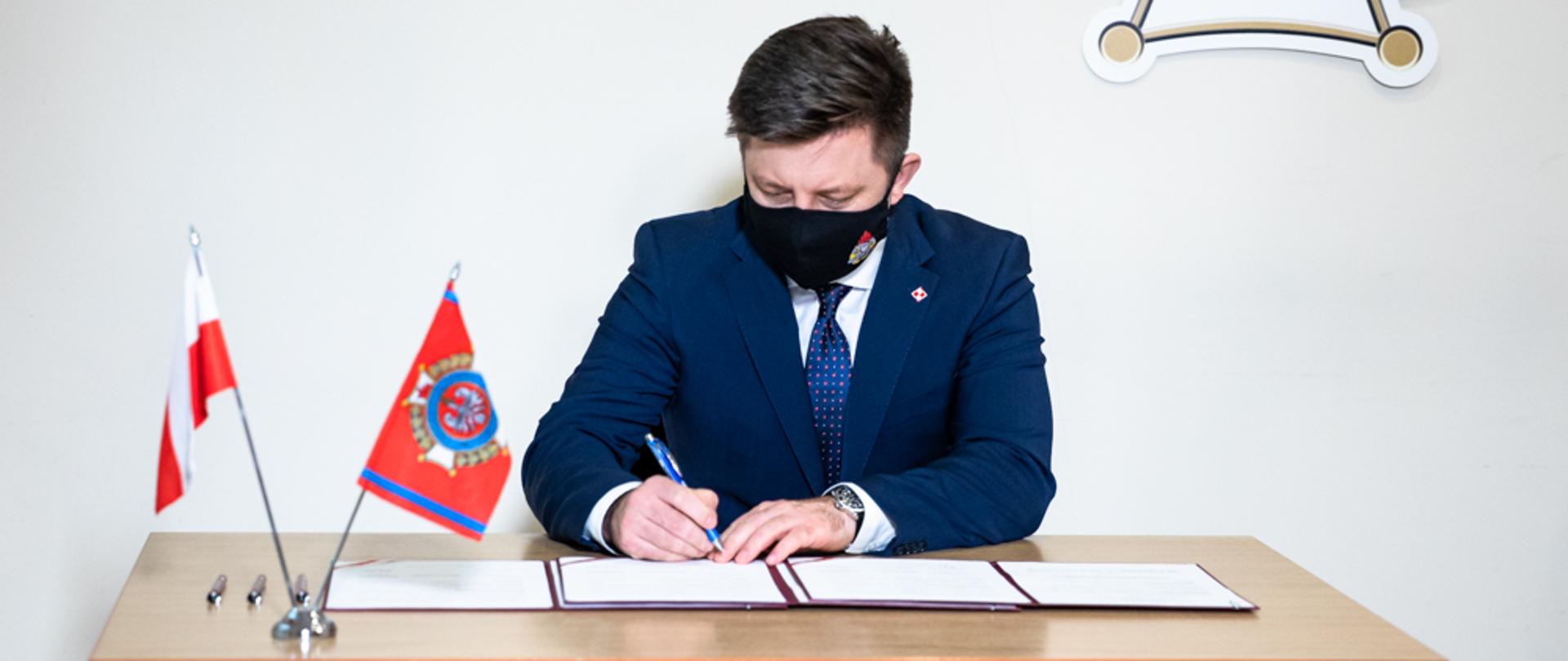 Minister Michał Dworczyk podpisuje dokument.