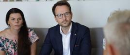 Minister rozwoju i technologii Waldemar Buda na spotkaniu z mieszkańcami osiedla przy ul. Kolejowej w Zgierzu, minister siedzi na kanapie i wysłuchuje mieszkańców osiedla przy ul Kolejowej