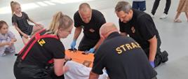 Strażacy przekładają poszkodowanego