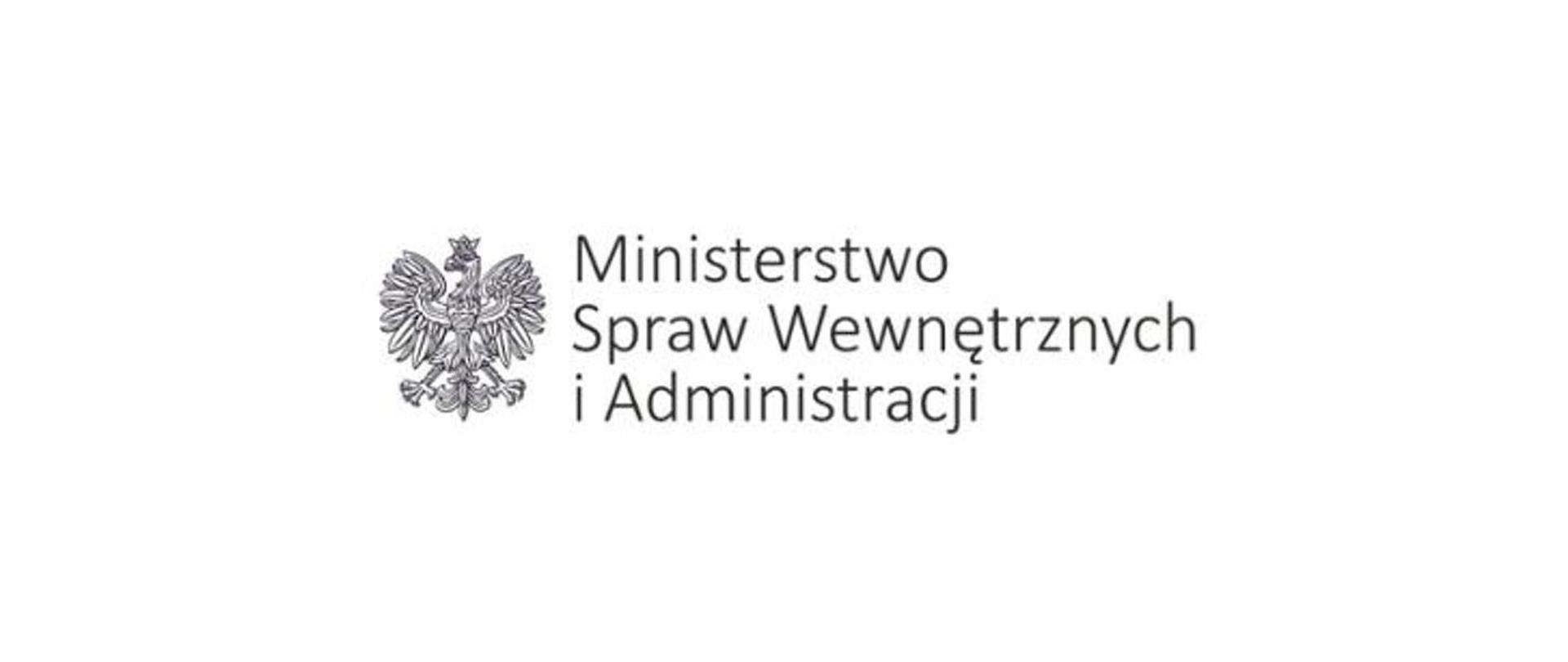 Na białym tle orzeł w koronie. Po jego prawej stronie napis Ministerstwo Spraw Wewnętrznych i Administracji