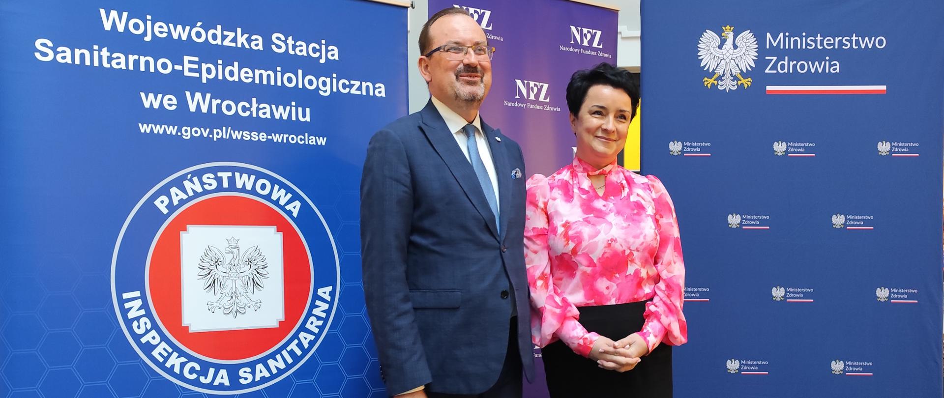 Osoby stojące przed banerami instytucji państwowych